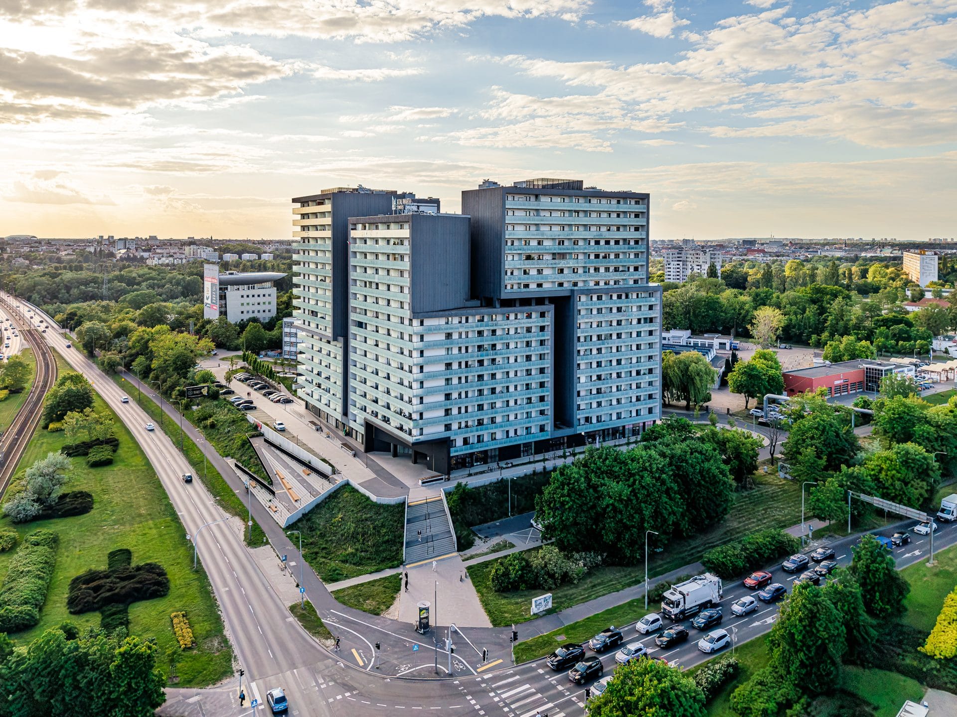 Wielokondygnacyjny budynek w Poznaniu otoczony zielenią, zdjęcie z drona